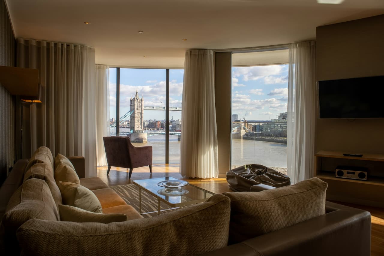 Living room of a London apartment with a large window and warm evening light