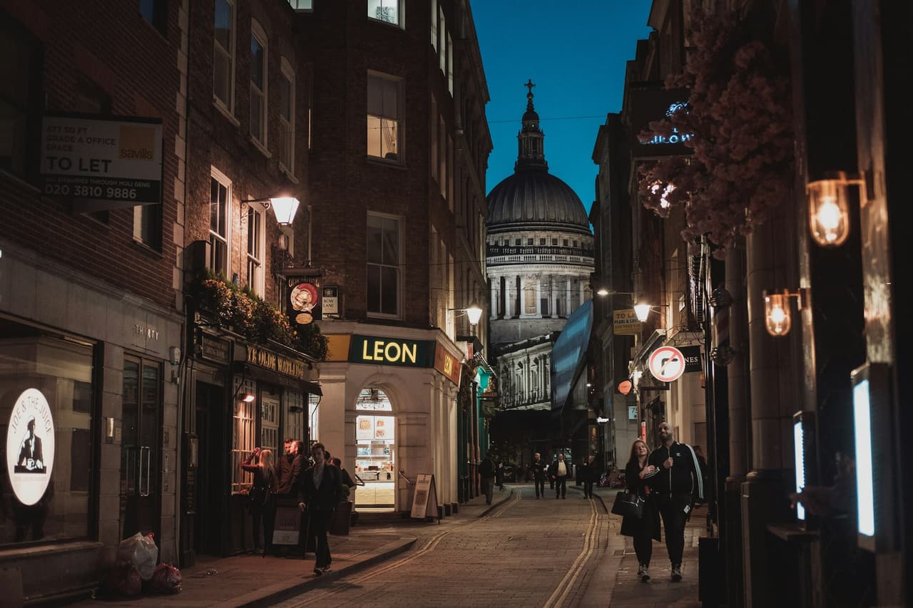 Illuminated shopfronts on a Soho street in London at night